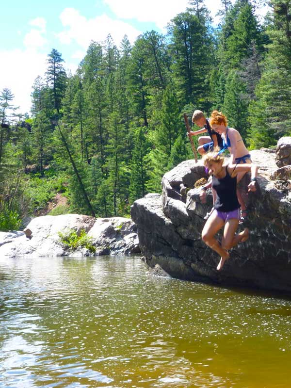 A family jumping in the river to swim