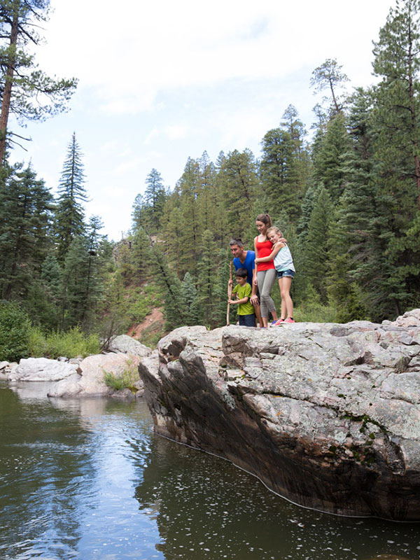 A family standing on a rock overlooking the Rio Brazos