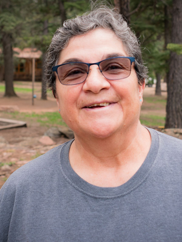 Smiling woman with short grey hair and transition glasses