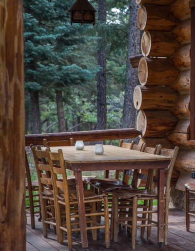 Picnic table and chairs on patio porch of log cabin