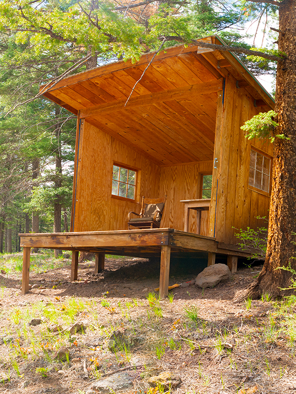 Half wooden cabin with chairs and windows