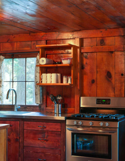 Kitchen with Stove, Sink, wooden walls and shelves