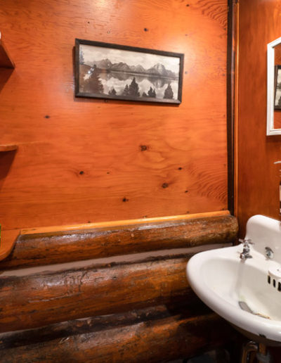 Log cabin wooden bathroom with antique sink