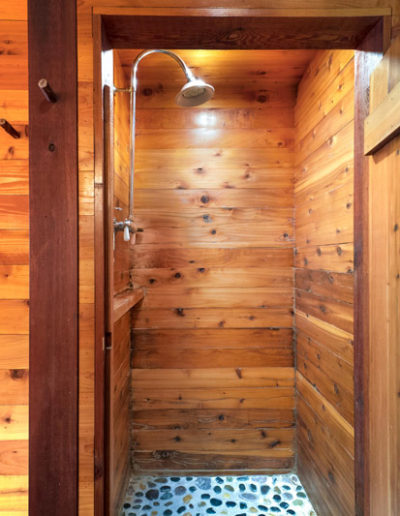 Wood lined shower with river rock floor