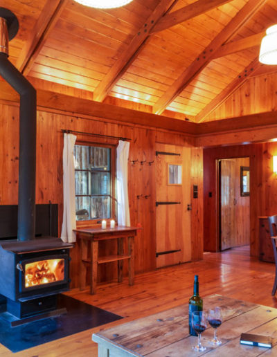 A view of the living room of the penasco cabin with table and wood burning fireplace