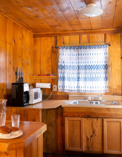 Wood kitchen with counters, wood cabinets, sink, stove, fridge, window