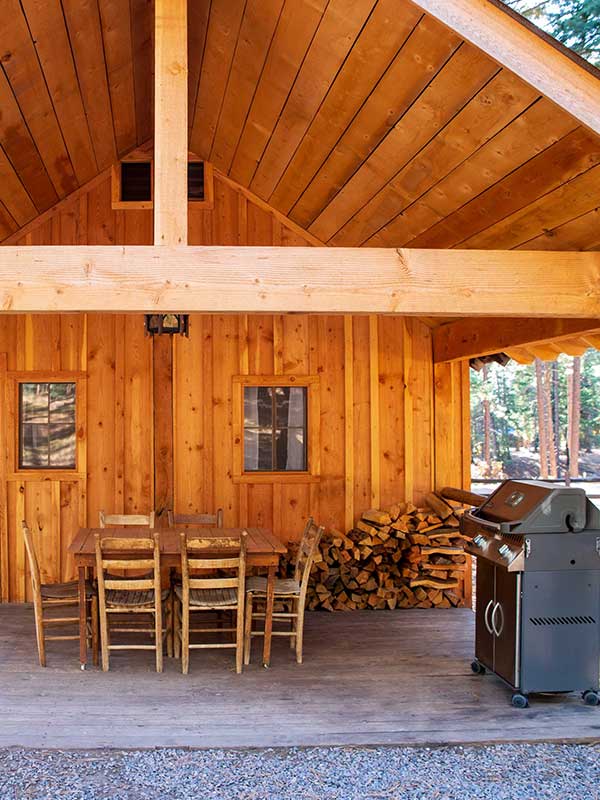 A view of the Bunkhouse patio with grill, table, and firewood