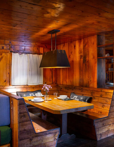 Wood kitchen table and fixed benches in bunkhouse wood cabin