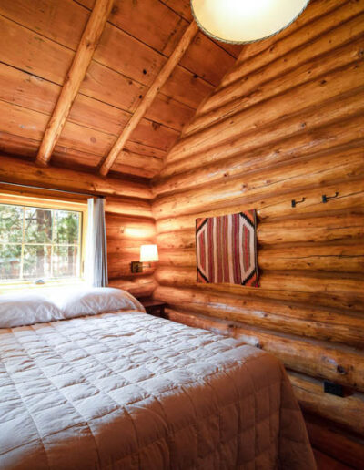 Log cabin bedroom with bed with white duvet