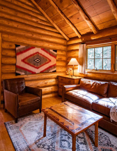 Log cabin living room with couches, chairs and coffee table