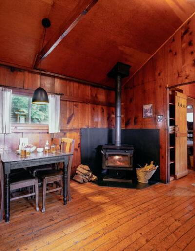 Wood cabin interior with living room and kitchen and wood floors, walls and ceilings