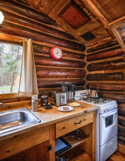 Tipton cabin kitchen with double sink, stove and cutting board.