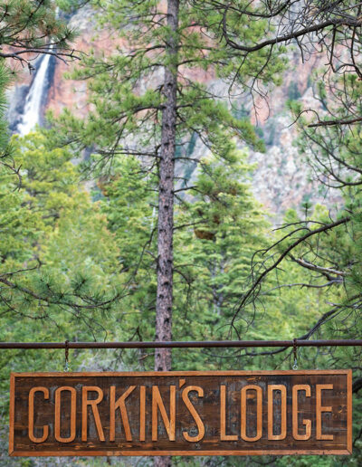 Corkins Lodge sign with waterfall in the background