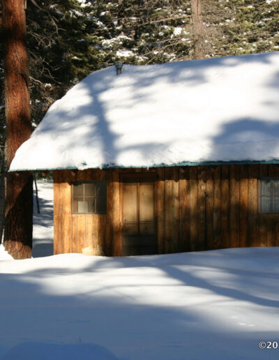 Cabin covered with snow and snow on the ground