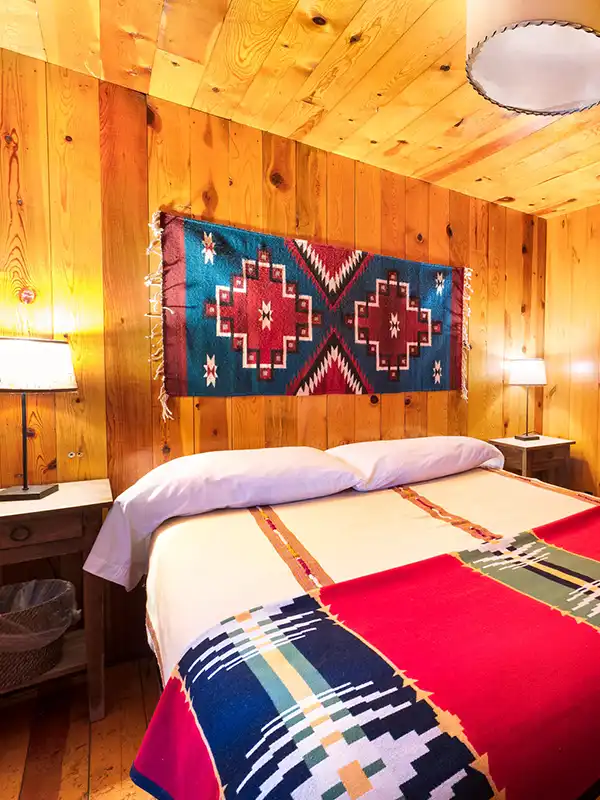 Wood paneling walls and ceiling with king bed with Pendleton blankets. 