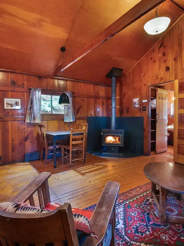Wood cabin interior with wood burning stove and tables and chairs