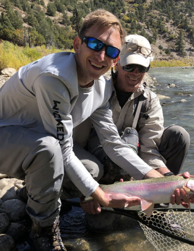 Men holding rainbow trout in the river