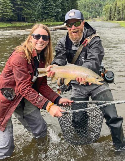 Man and Woman holding large brown trout