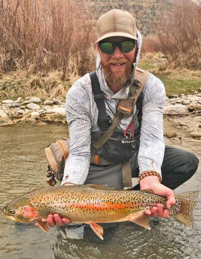 Man holding rainbow trout in the river